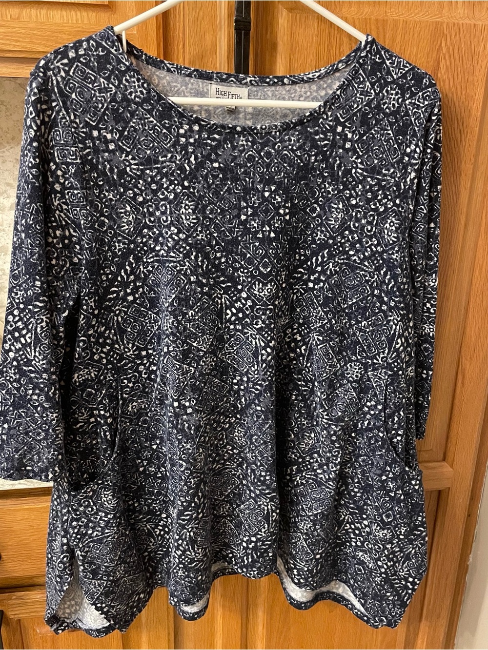 Women’s navy and white knit top with 3/4 sleeves and round neck.
